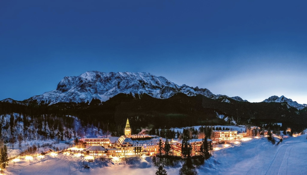 Schloss Elmau bei Dämmerung, Panoramaaufnahme mit verschneiten Bergen